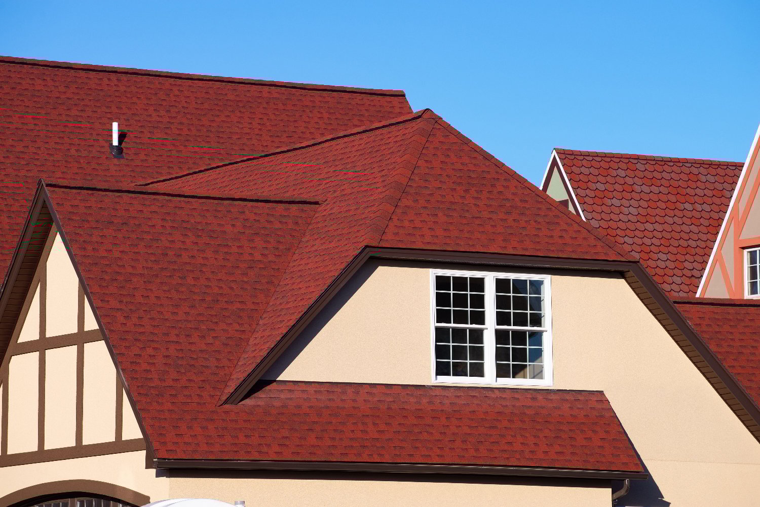 The image depicts a house's roof with red shingles