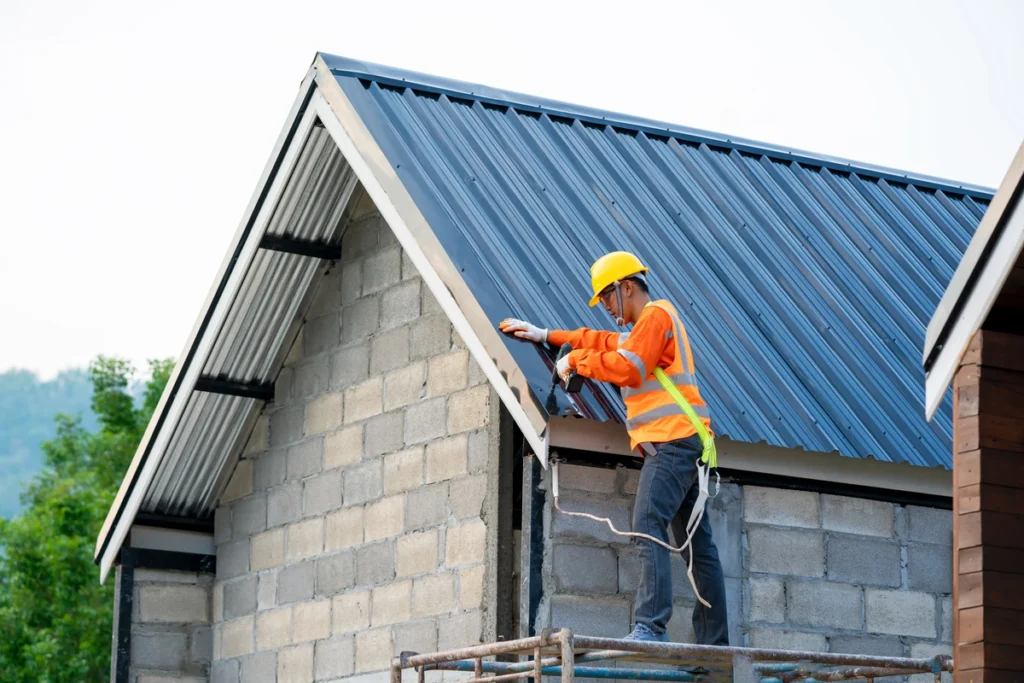 roof tech on ladder repairing metal roof