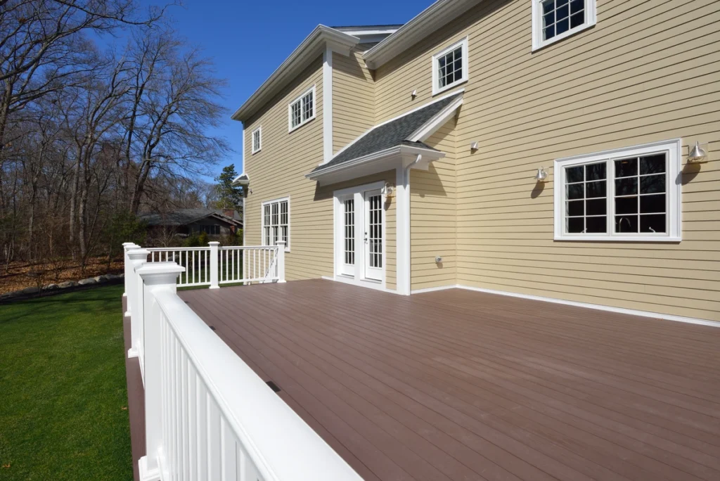 decks canby-dark wood deck with white railing against a yellow sided home
