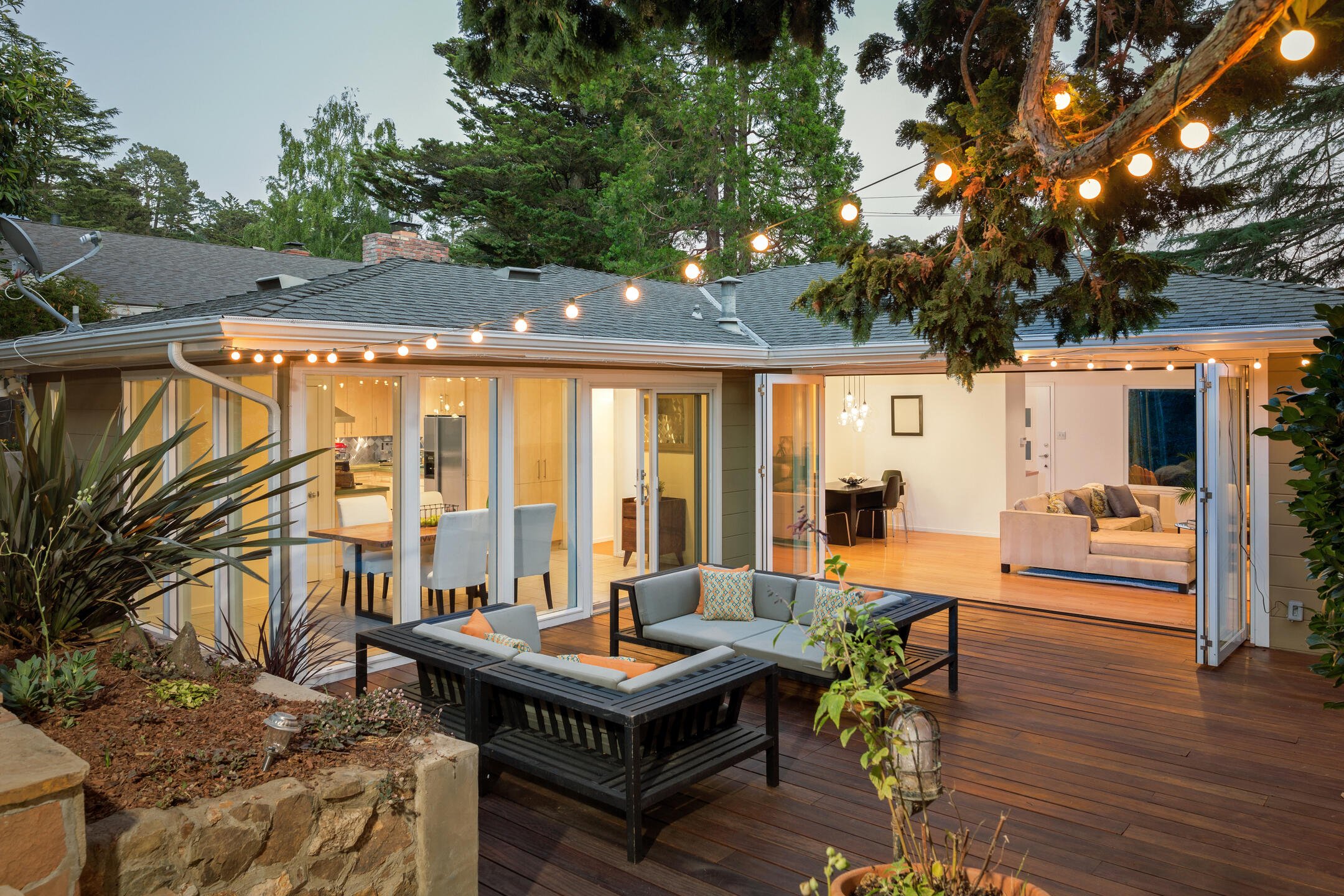 deck styles-charming deck with ambient lighting strung in trees