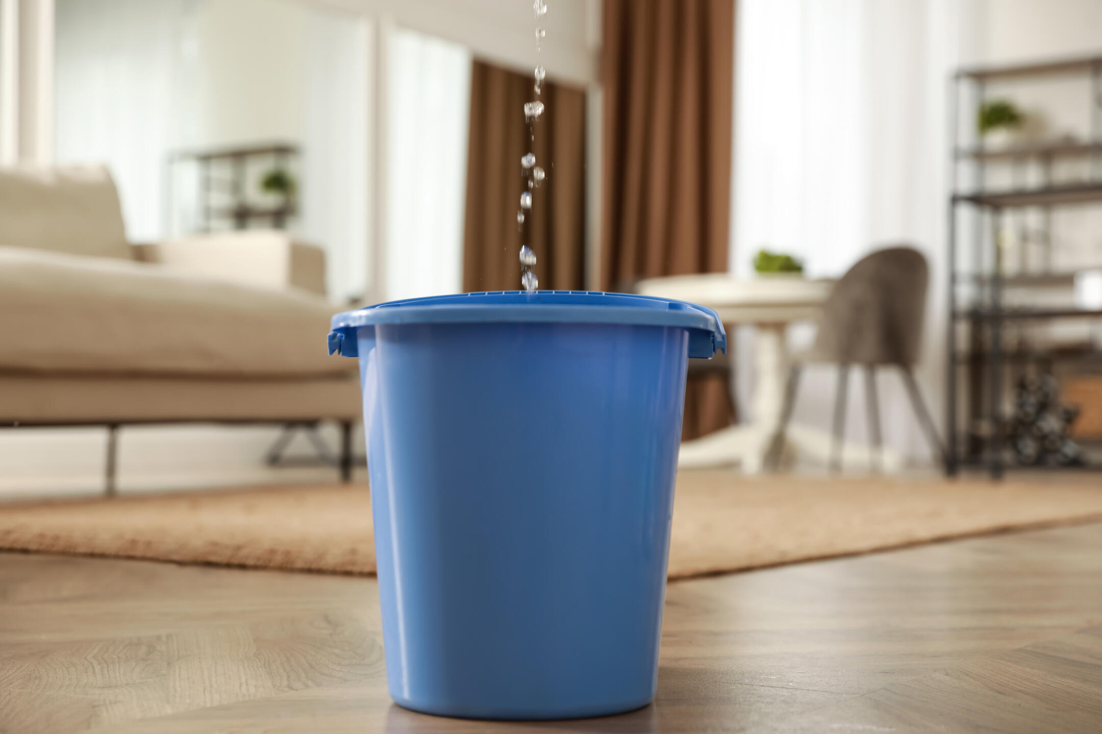 how to find a roof leak-ceiling leak dripping into a blue bucket in a living room