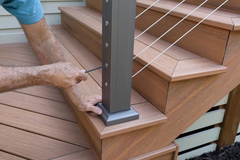 how to install deck railing-man using hand tools to install deck railing