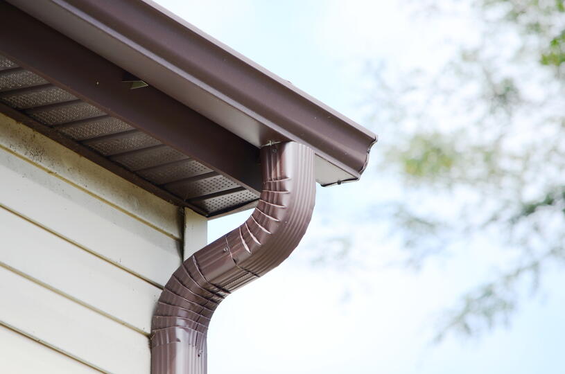 roof overhang-brown roof overhang and gutters and downspouts