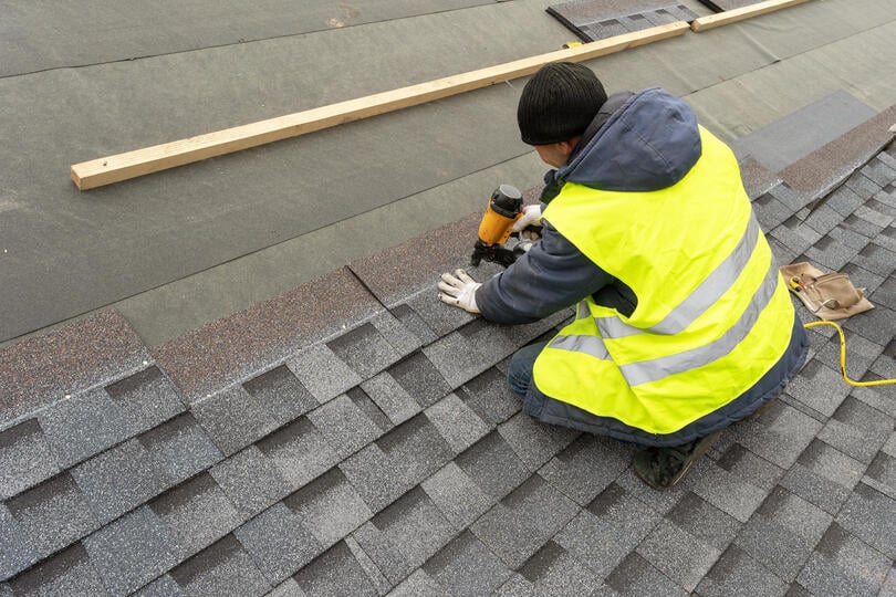 roofing tools-technician using power tools to install roof shingles