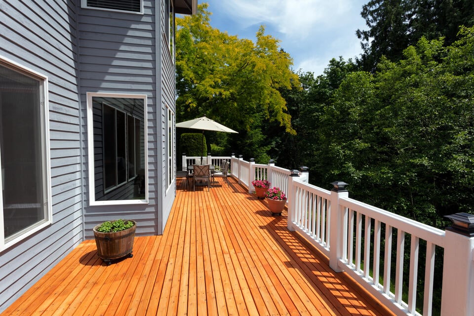 best decking material-house with a wood stained deck and white railing