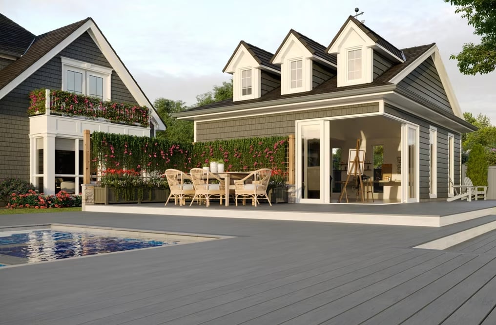 trex-large gray deck built next to a multi building home