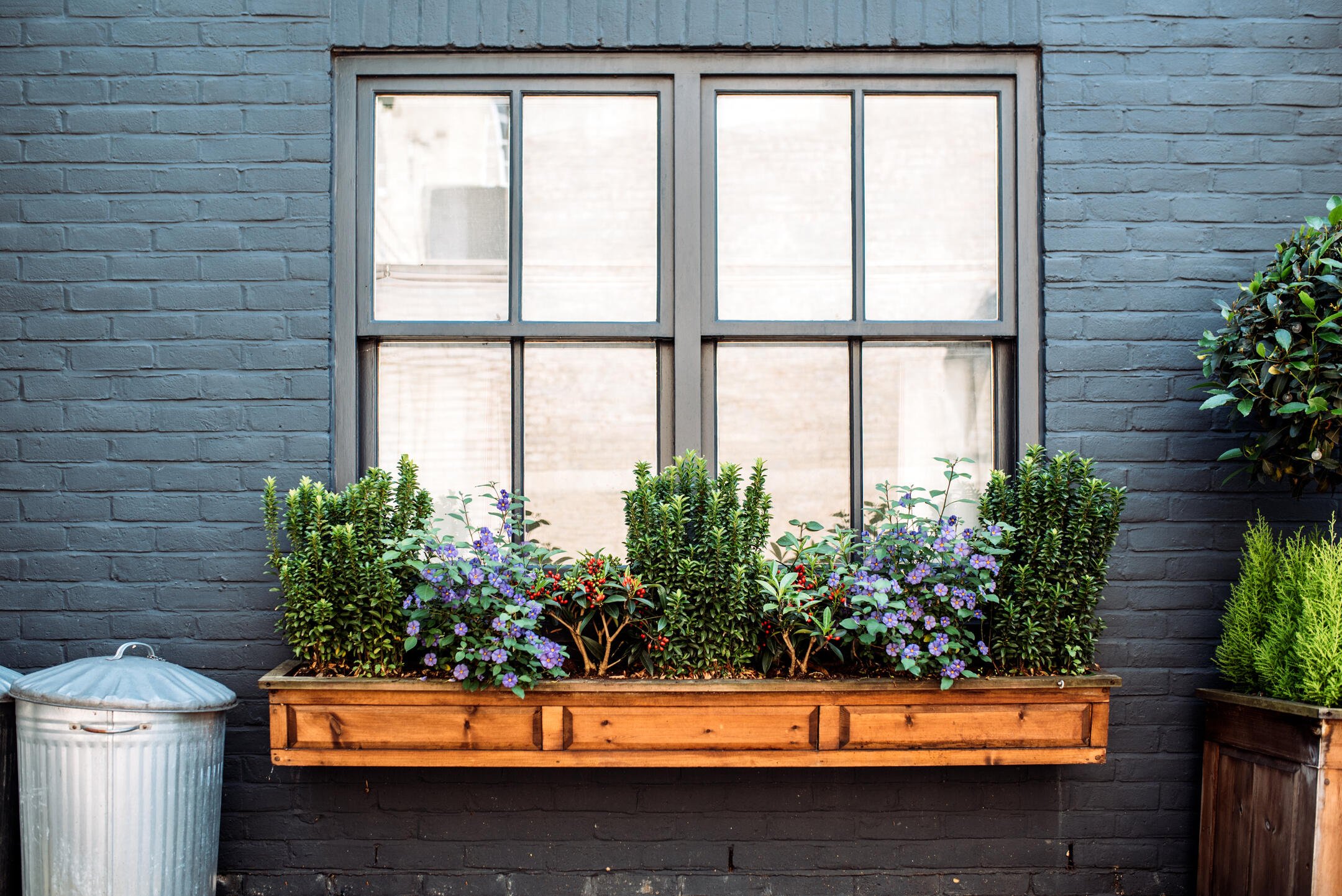 window trim ideas-exterior view of black brick house with black window trim