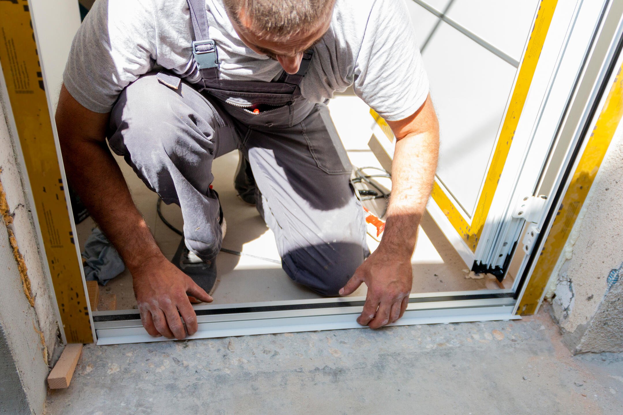 entry door installation-close up of tech installing track for front door