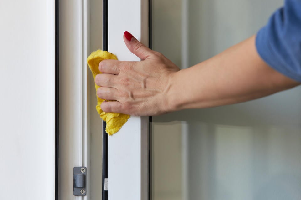 front door styles-woman cleaning front door for maintenance