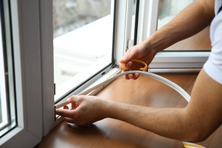window seal repair-close up of man installing new seal materials on hinged window