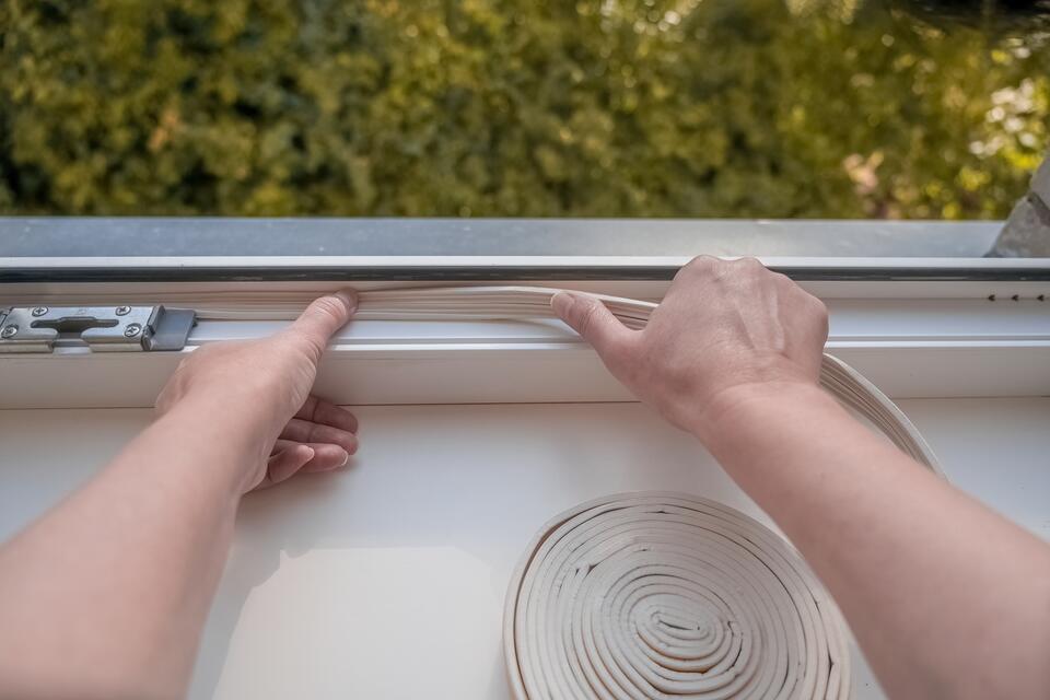 window seal repair-close up of person installing new seal materials into base of window