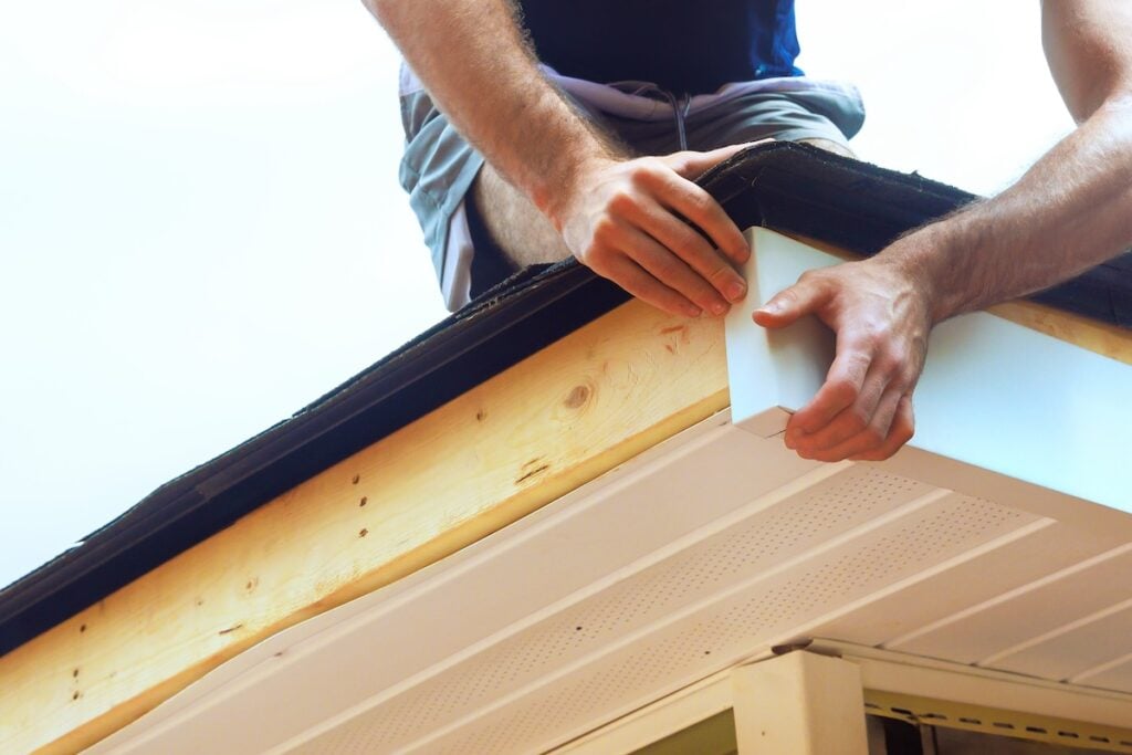 worker installing metal roof trim