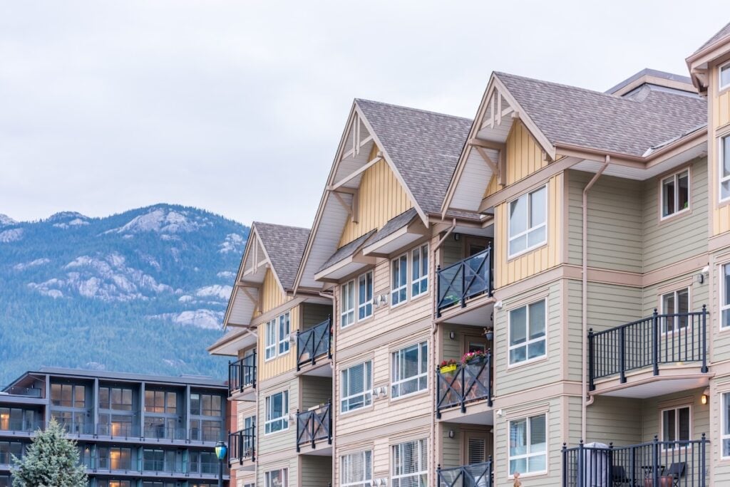 The top of an apartment building with nice windows.