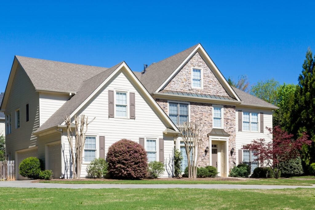 Stone and Vinyl Siding House in Spring under blue sky