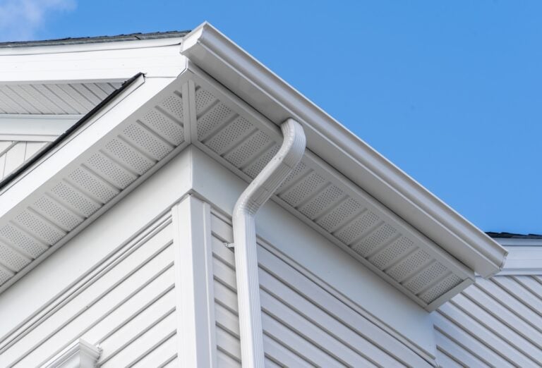 Colonial horizontal vinyl lap siding, soffit with ventilation, gutter and guard, eaves with elbow, drip, on a new construction American single family home