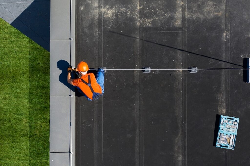 roofer looking at roofing system on commercial roof