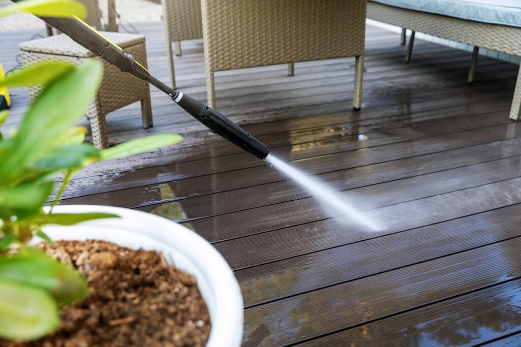 cleaning wooden terrace planks with high pressure washer