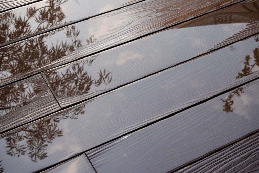 puddles on plastic composite decking with wood grain. 